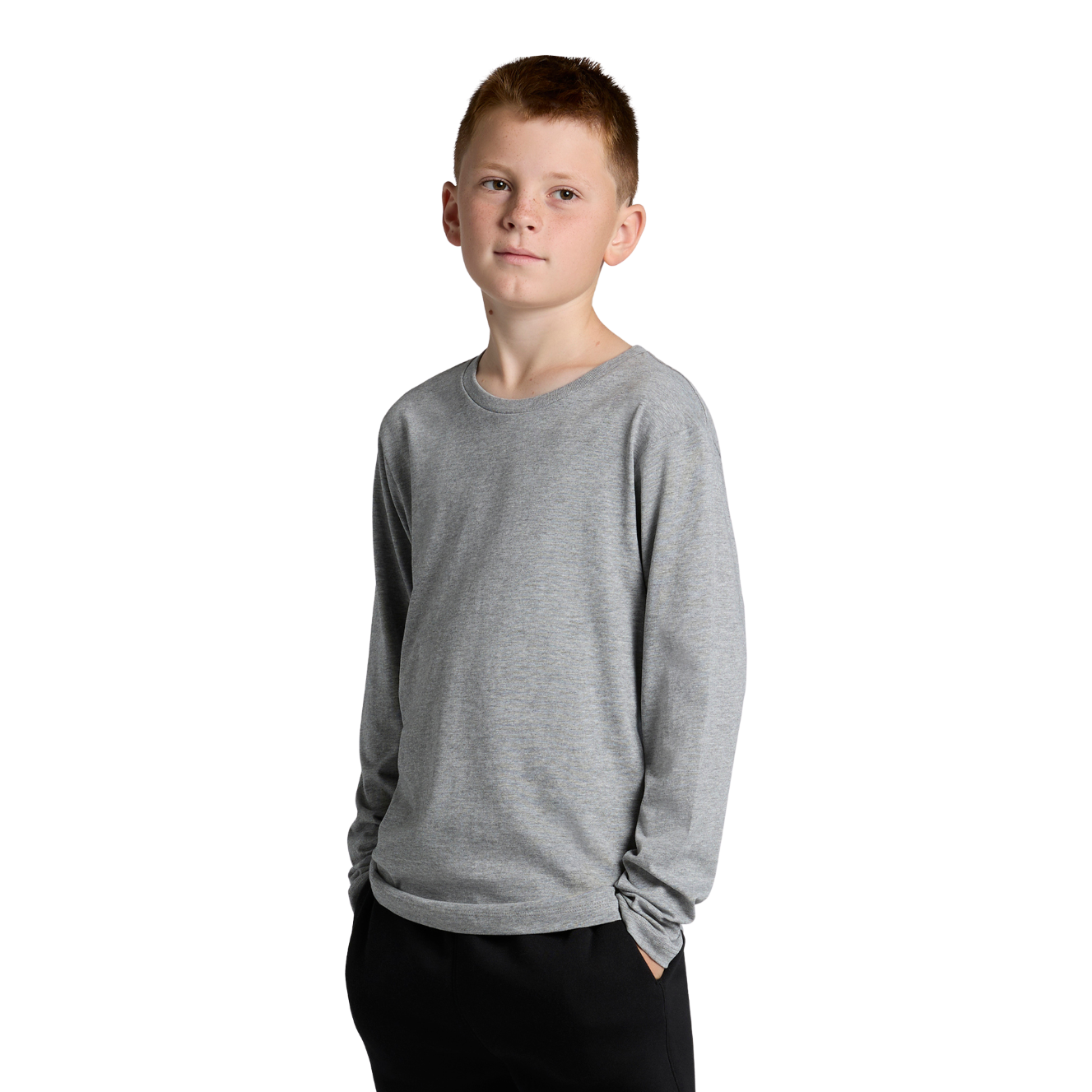 Front view of youth wearing a grey AS Colour Youth Staple Long Sleeve T-shirt with hands in pockets