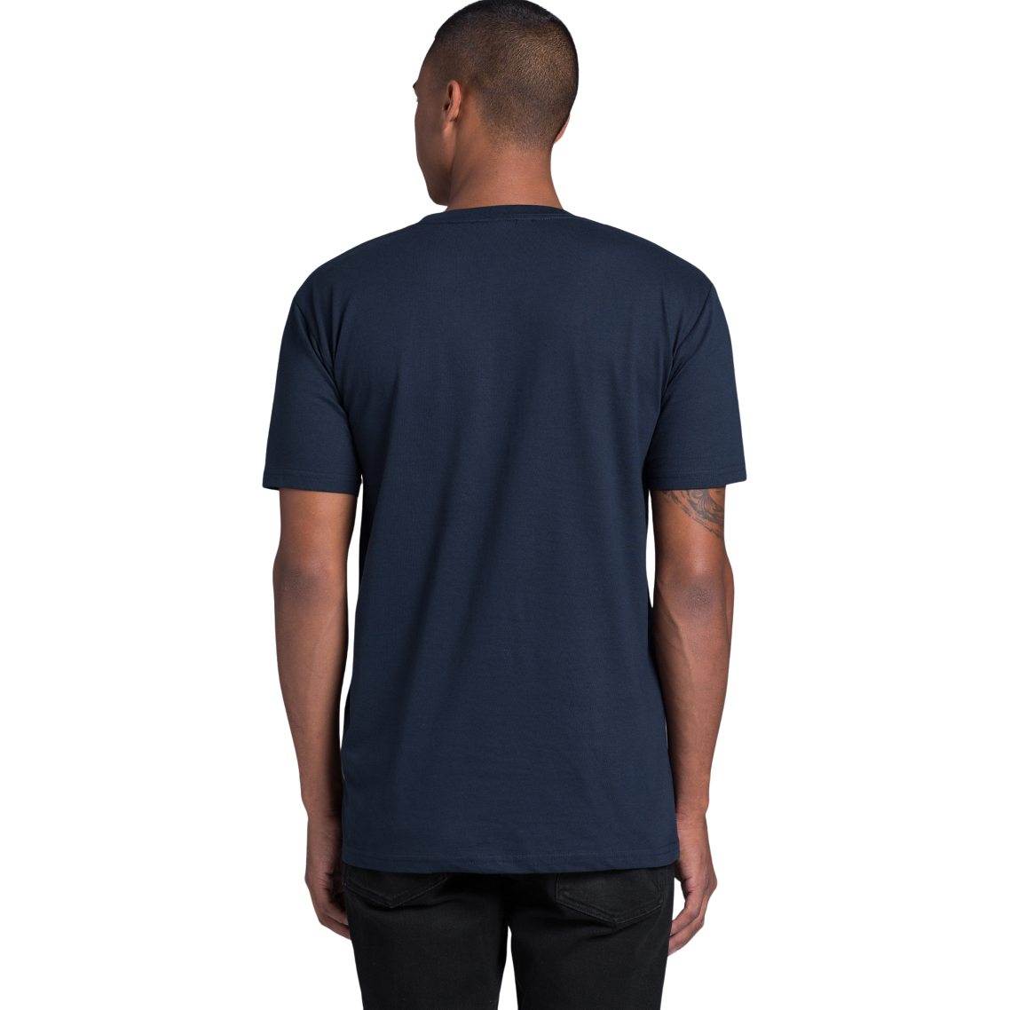 Back view of man wearing navy AS Colour Staple T-shirt looking slightly to the left with hands by side