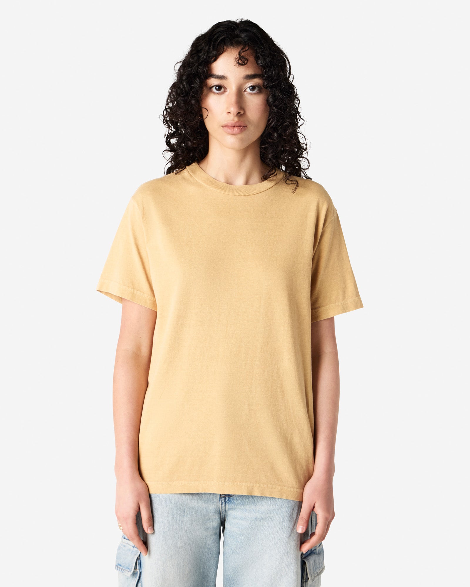 Front view of woman wearing faded mustard American Apparel Heavyweight Unisex T-Shirt looking straight ahead