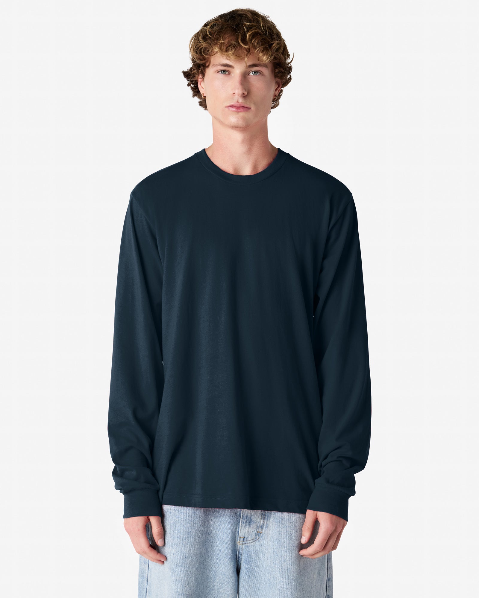Front view of man wearing navy American Apparel Fine Jersey Long Sleeve Unisex T-shirt looking straight ahead