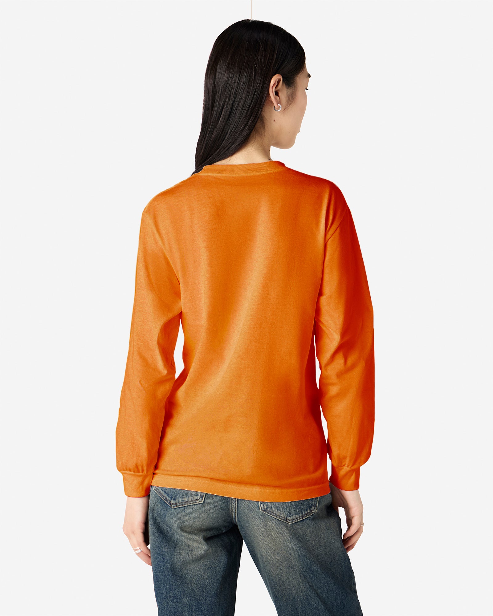 Back view of woman wearing orange American Apparel Heavyweight Long Sleeve Unisex Crew Neck T-shirt looking to the right with hair over left shoulder