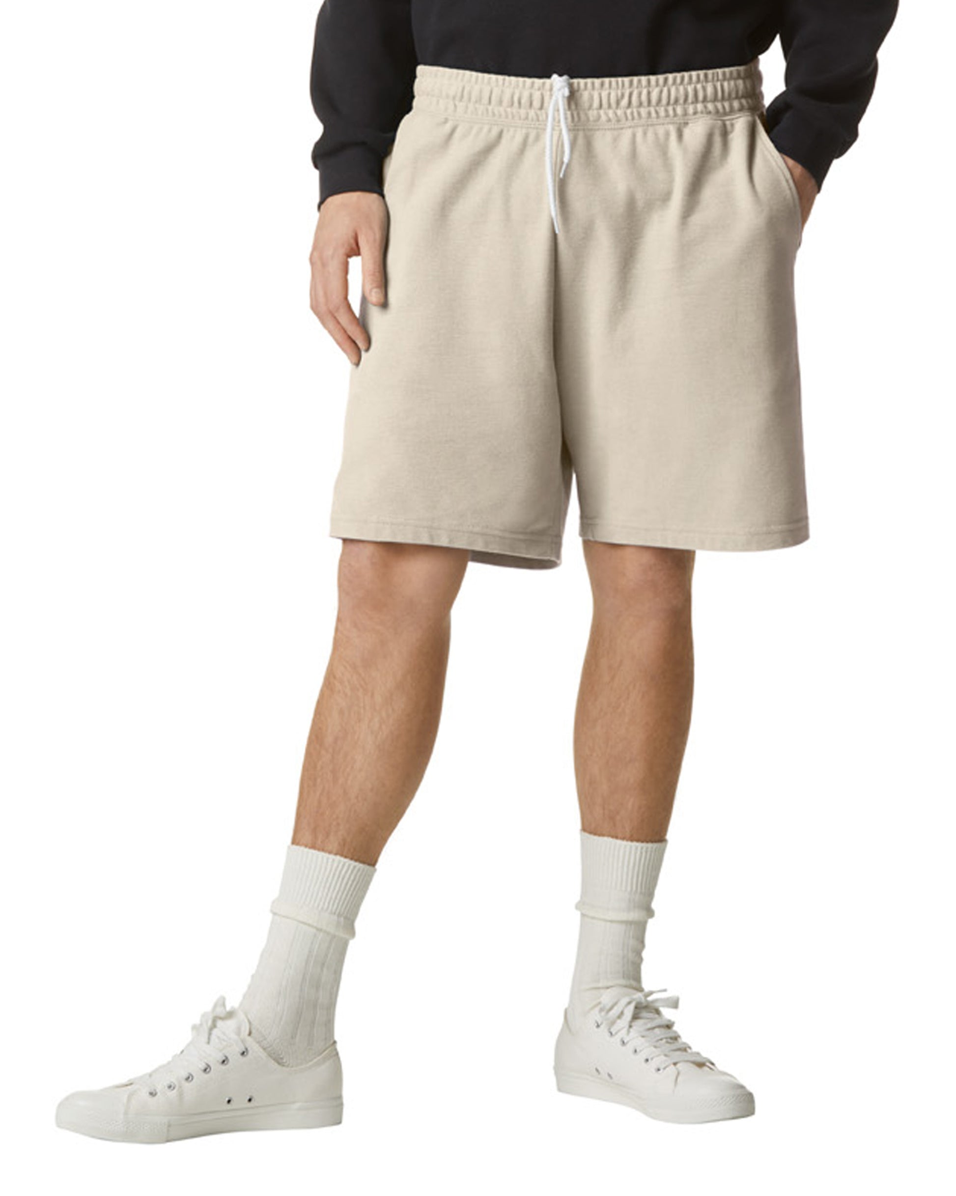 Front view of man wearing bone coloured American Apparel Unisex Pique Gym Shorts with left hand in pocket