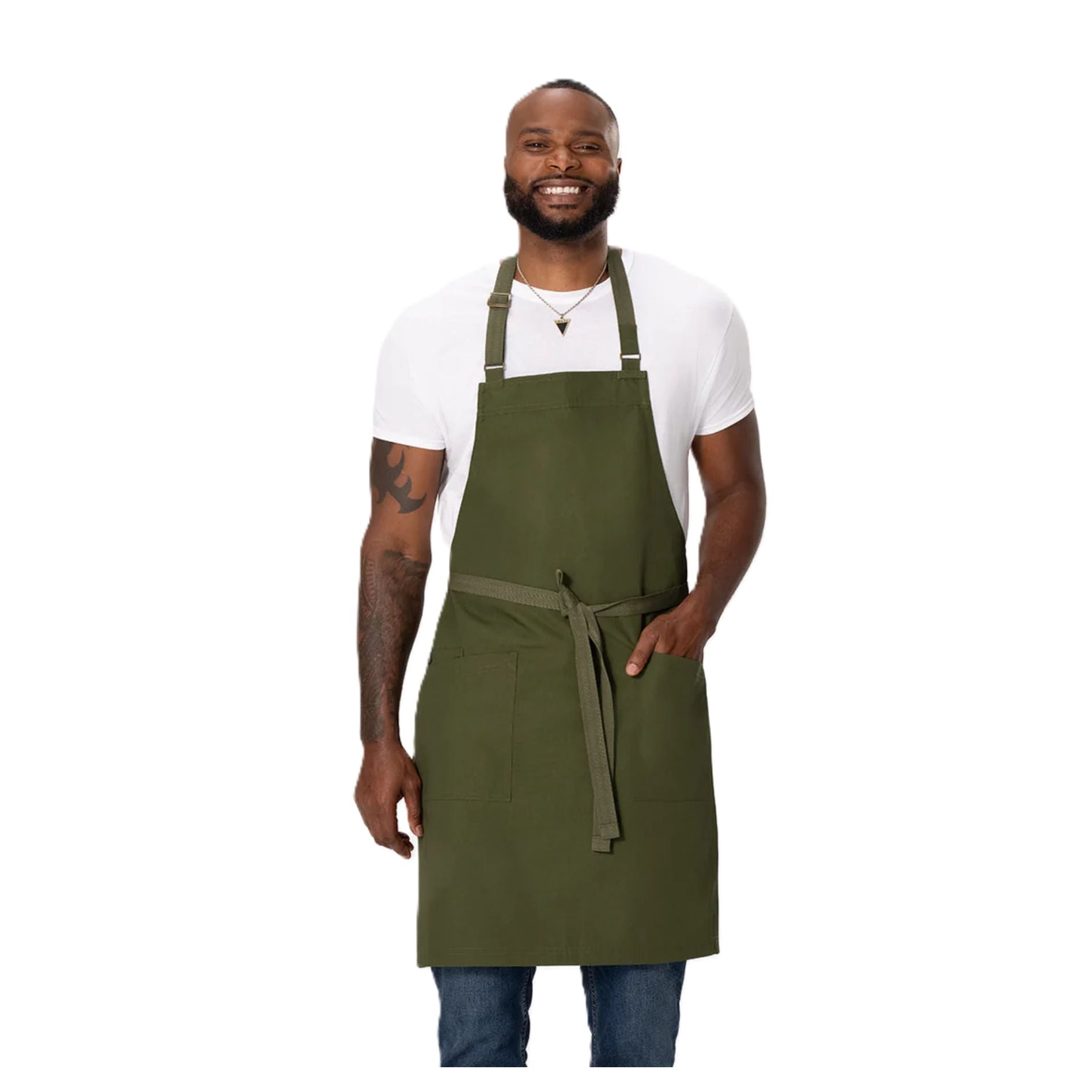 Front view of a man smiling, wearing the Chef Works Eco-Friendly Bib Apron with Pockets with hand in one pocket.