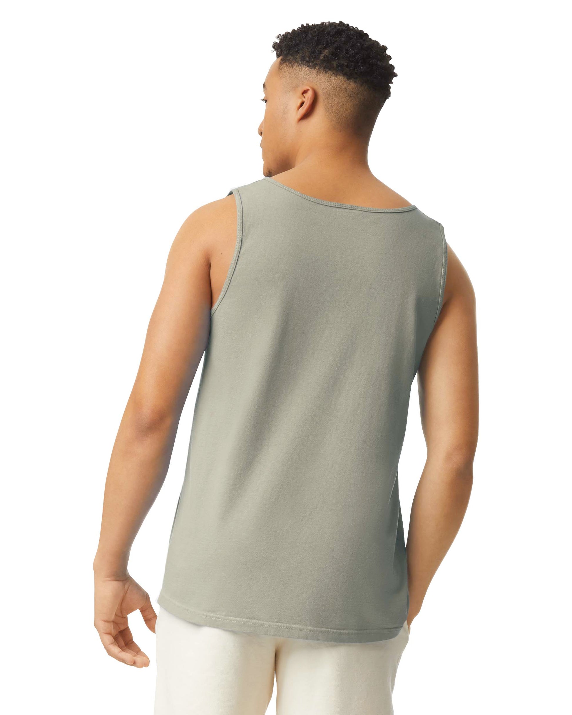Back view of man wearing sandstone coloured Comfort Colors Adult Tank with right hand in pocket looking left