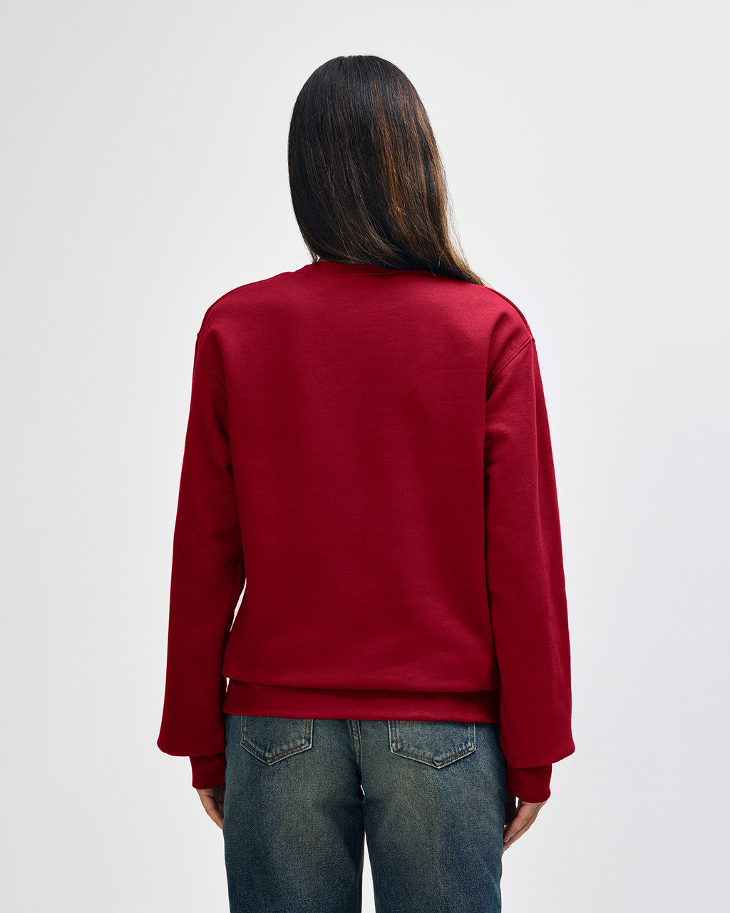 Back view of woman wearing cherry red Gildan Hammer Maxweight Adult Sweatshirt with long hair over right shoulder
