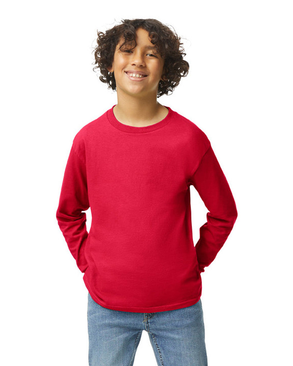 Front view of youth wearing red Gildan 5400B Heavy Cotton Youth Long Sleeve T-Shirt smiling with hands behind back