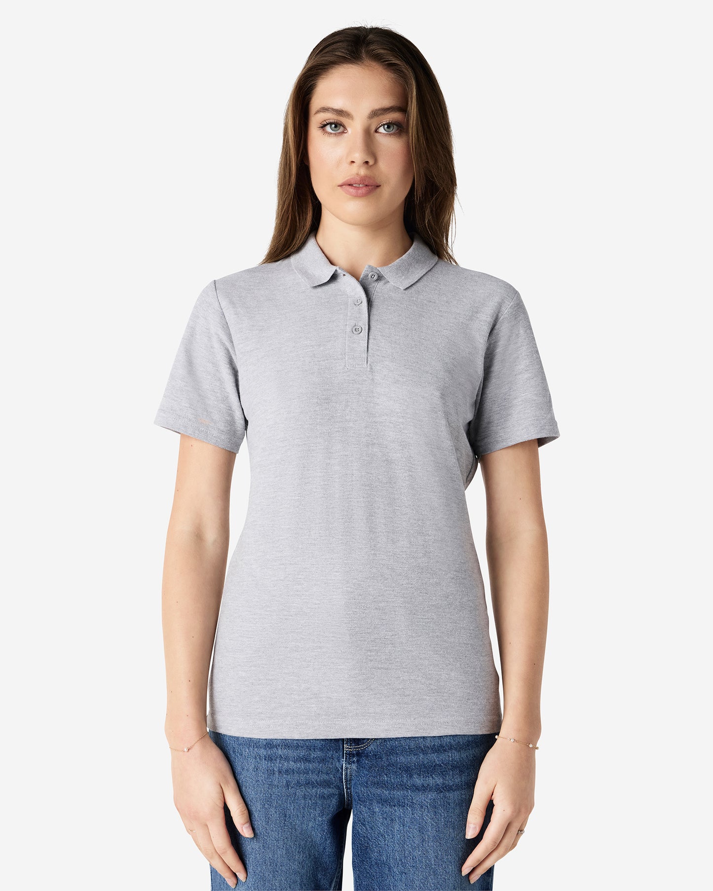 Front view of woman wearing grey Gildan Ladies Pique Polo Shirt looking straight ahead with arm by side