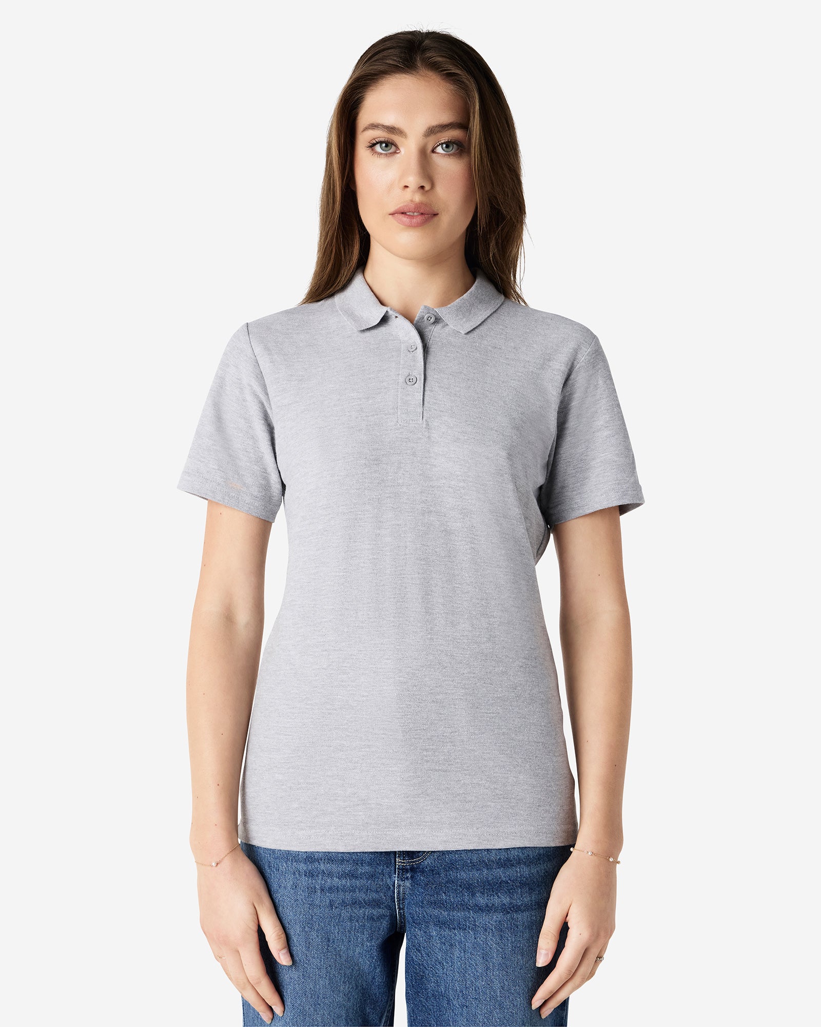 Front view of woman wearing grey Gildan Ladies Pique Polo Shirt looking straight ahead with arm by side