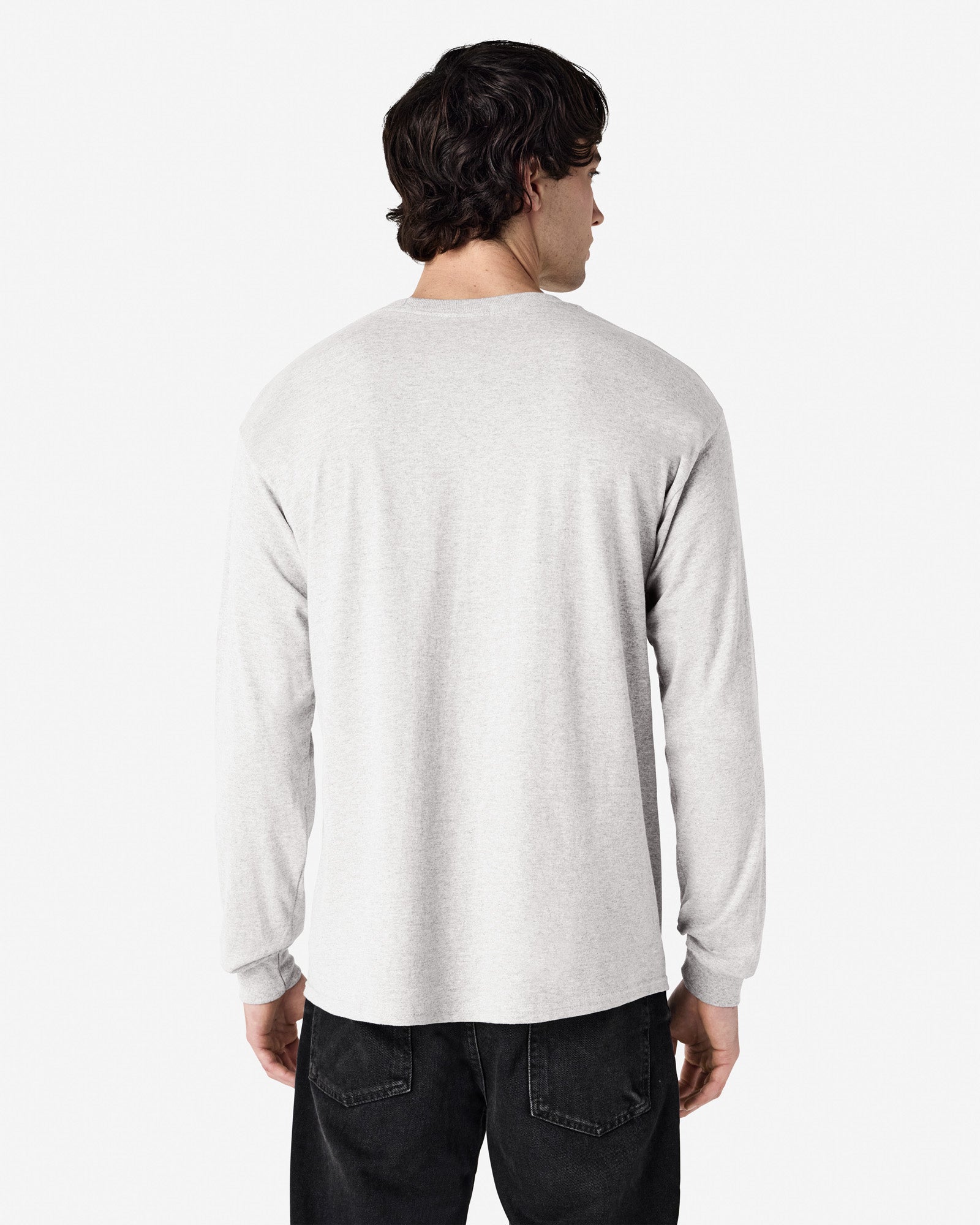 Back view of man wearing ash grey Gildan Adult 5400 Long Sleeve Heavy Cotton T-Shirt looking right