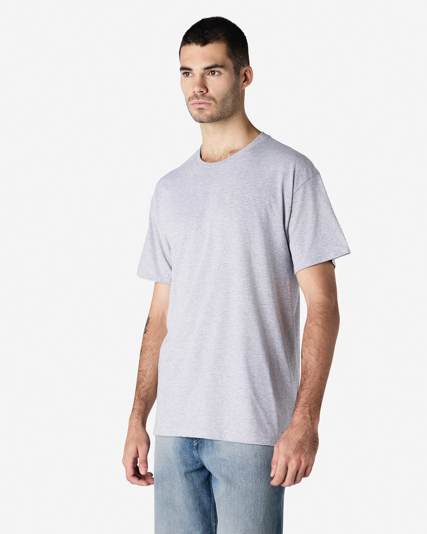 Front view of man wearing light grey Gildan Light Cotton Adult T-shirt standing slightly side-on