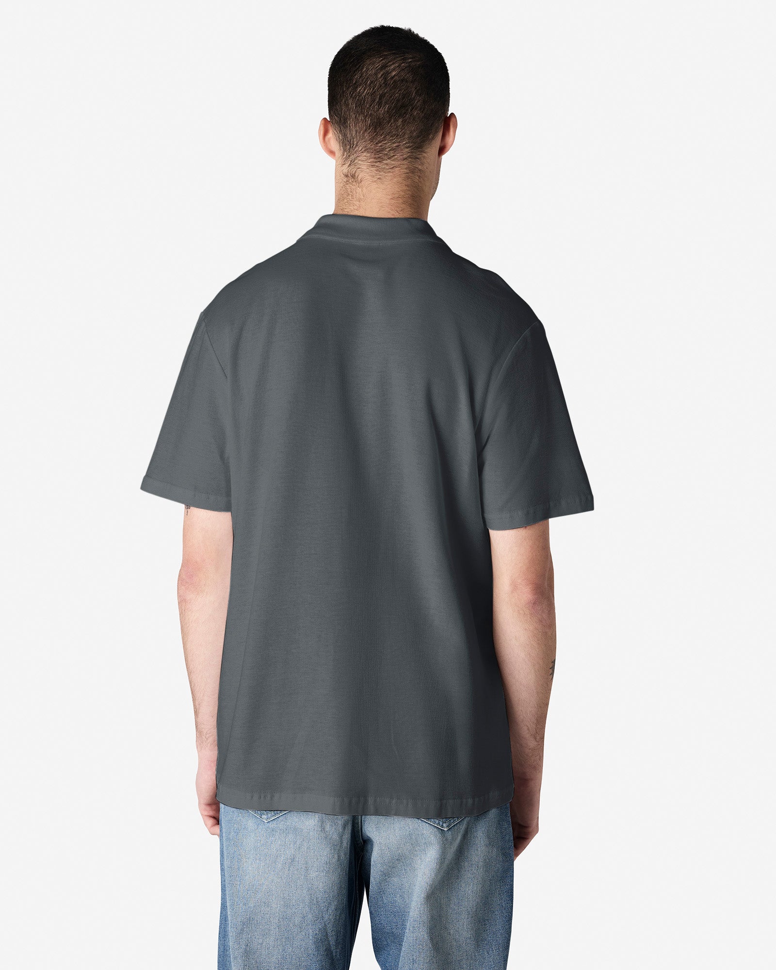 Back view of man wearing a grey Gildan Softstyle 64800 Mens Polo Shirt with hands by side